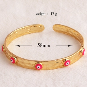 Dettaglio macro del bracciale dorato testurizzato con malocchio rosso e diametro 58mm