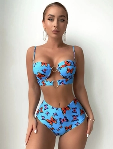 Détail du bikini bleu clair avec imprimé papillon et anneau métallique décoratif