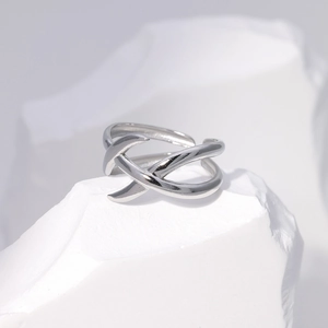 Macro view of adjustable silver geometric ring resting on a white textured stone