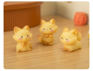 Detailed close-up of three miniature resin foxes with vibrant yellow finish for decor