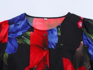 Close-up of elegant round neckline and button detail on black floral chiffon blouse
