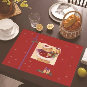 Detailed view of a red Christmas placemat with cartoon bear and snowflake on wooden table