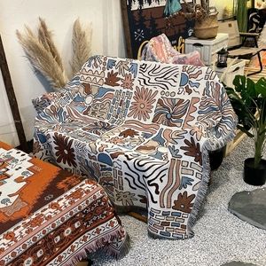 Bohemian woven cotton picnic blanket with sun patterns and decorative fringe edges
