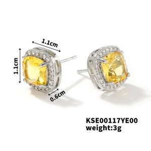 Macro detail of square yellow gemstone earrings with halo diamonds and side engraving