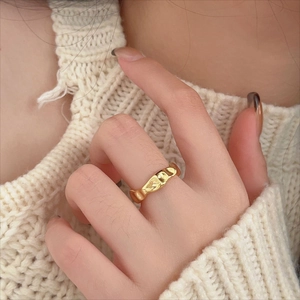 Chunky irregular liquid metal gold ring with minimalist textured finish on hand