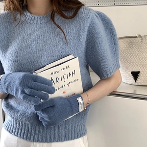 Cozy blue knitted winter touchscreen gloves for women shown in a lifestyle indoor setting