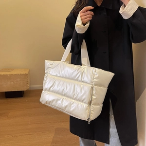 White puffer tote gym bag shown on shoulder with horizontal quilted down cotton finish