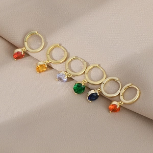 Detailed view of six gold hoop earrings with multi-colored cubic zirconia pendants
