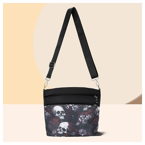 Detail of gothic crossbody bag with white skull and dark purple floral pattern