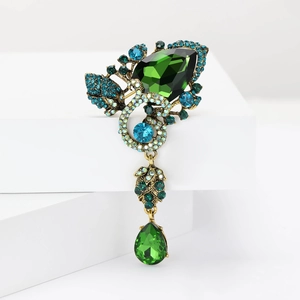 Detailed view of a vintage alloy brooch with green pear-cut crystals and blue rhinestones