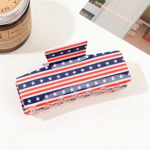Detail of a large shark hair clip with American flag pattern on a minimalist background