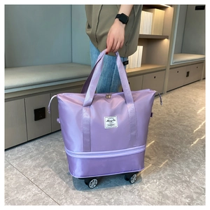Detail of purple expandable travel bag with swivel wheels and reinforced handles