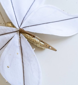 Detail view of the metal crocodile clip on back of white and gold Christmas butterfly