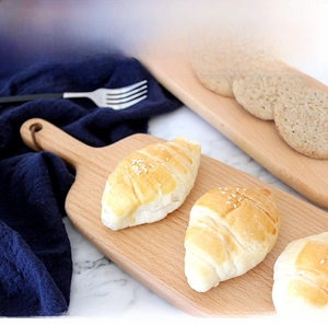 Detail of solid beech wood bread board with handle hole on marble surface