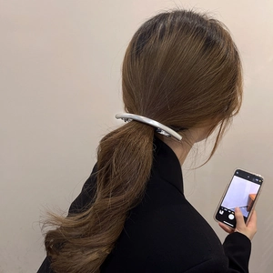 Sleek silver metal hair claw clip styled on a low ponytail for an elegant hairstyle