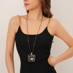 Détail du collier à double chaîne avec pendentif géométrique mat sur un mannequin