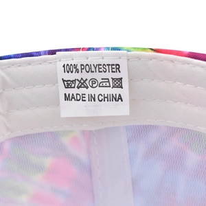Close-up of internal white sweatband and polyester care label on tie-dye baseball cap