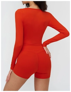 Vue arrière détaillée de l'ensemble de yoga orange avec haut à manches longues et short gainant