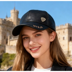 Detail of black leather baseball cap with NY&JA embroidery and vintage metal badge