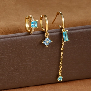 Macro shot of S925 engraved stamp on gold zircon earrings set against brown leather