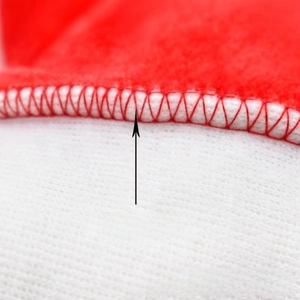 Detail shot of high-quality red and white plush fabric with precise overlock stitching edge