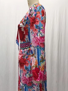 Detail view of colorful floral print long dress with vintage V-neck and decorative waistband
