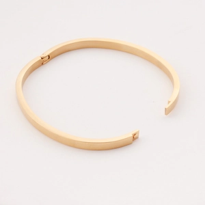 Minimalist gold oval hinge bangle in polished stainless steel for a sleek female look
