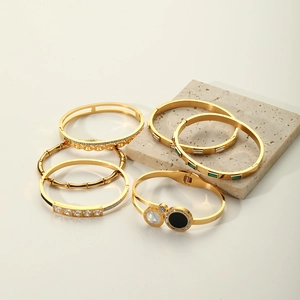 Detailed view of 18K gold plated stainless steel bangles with textured geometric designs