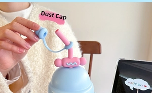 Close-up of cute macaron pink silicone dust cap with strap for straw water bottles