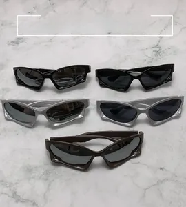 Flat lay of futuristic Y2K sports sunglasses in black, silver and brown on marble surface