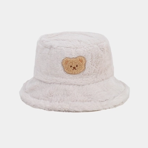 Close-up of beige faux fur bucket hat featuring a cute brown bear embroidery detail