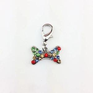 Detailed view of bone-shaped metal charm with multi-colored rhinestones and lobster clasp