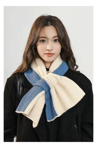 Close-up of sky blue and cream knit scarf showing rib-knit texture and patchwork design