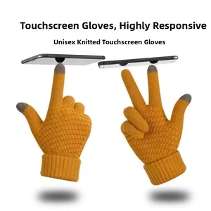 Close-up of ginger yellow knit gloves with grey touchscreen tips on index and thumb