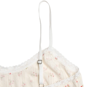 Detailed macro view of floral knit dress with lace trim and adjustable straps