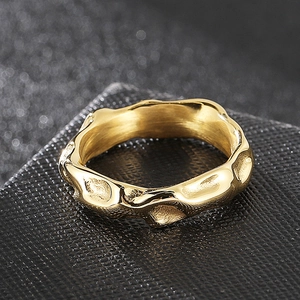 Macro detail of golden irregular lava texture on minimalist stainless steel ring