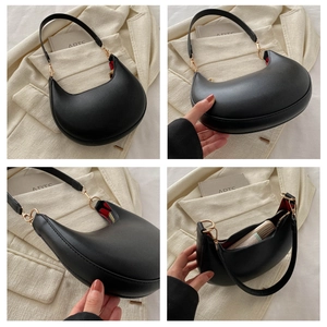 Detail view of crescent shoulder bag with golden hardware and red lining interior