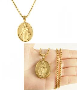 Dettaglio macro del ciondolo ovale della Vergine Maria in acciaio dorato con catena box