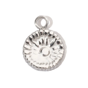 Detailed macro view of silver round stainless steel charm with radial embossed texture