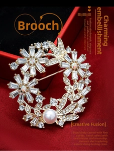 Macro shot of gold floral brooch with marquise crystals and a centered white pearl