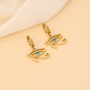 Golden Horus Eye earrings with blue gemstones on white silk background professional view