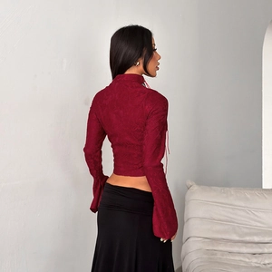 Detalle de la espalda acordonada y el tejido jacquard del crop top rojo burdeos