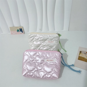 Close-up of heart quilted PU mini pouch in pearl white and metallic pink with colorful cord