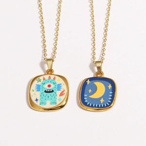 Detailed view of vintage gold evil eye pendants with blue enamel moon and monster patterns
