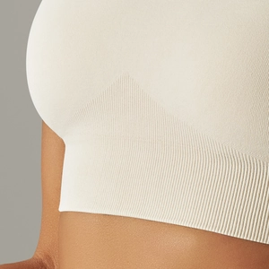 Detail of seamless knitted beige sports bra showing ribbed texture and fabric weaving