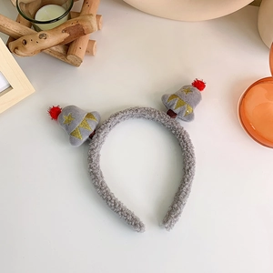 Detail of gray plush Christmas tree headband with golden embroidery and red pom-poms