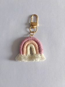 Close-up of handmade rainbow keychain with colorful cotton layers and golden metal clasp