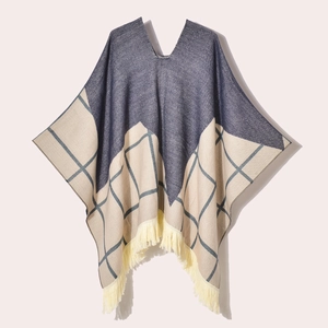Blue and beige geometric knit poncho with tassel trim and V-neckline flat lay