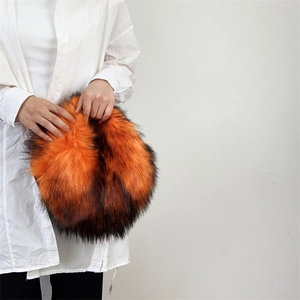 Detailed close-up of vibrant orange and black faux fur texture on a punk Y2K handbag