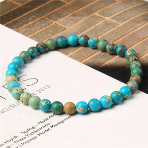 Macro view of blue-green imperial jasper beads showing natural stone textures on the bracelet